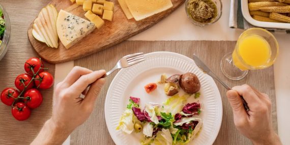 A vibrant lunch setting with salad, cheese, and orange juice, perfect for a healthy meal.